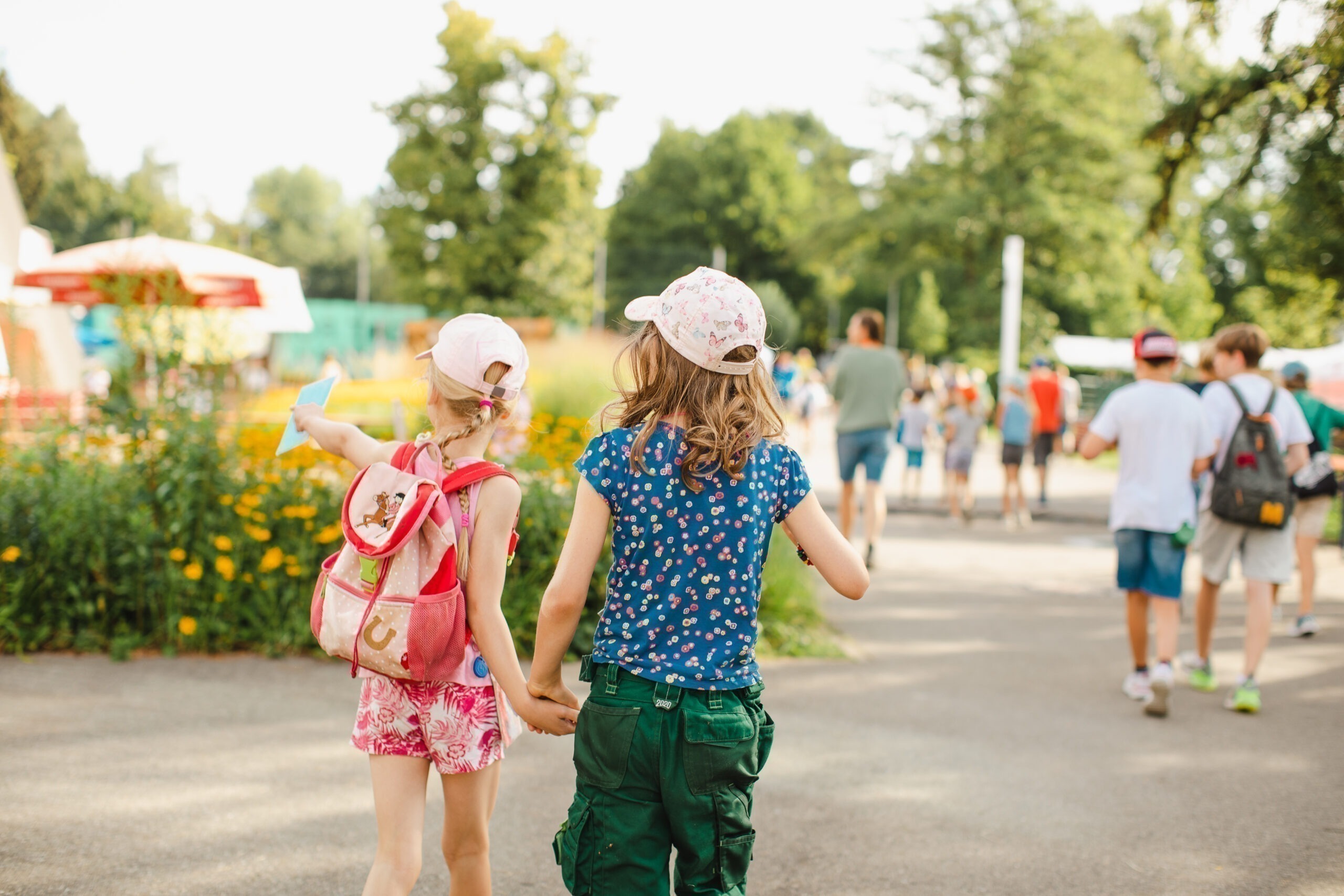 Zwei Spielkinder gehen gemeinsam über das Gelände der Spielstadt Bad Kresselnau.